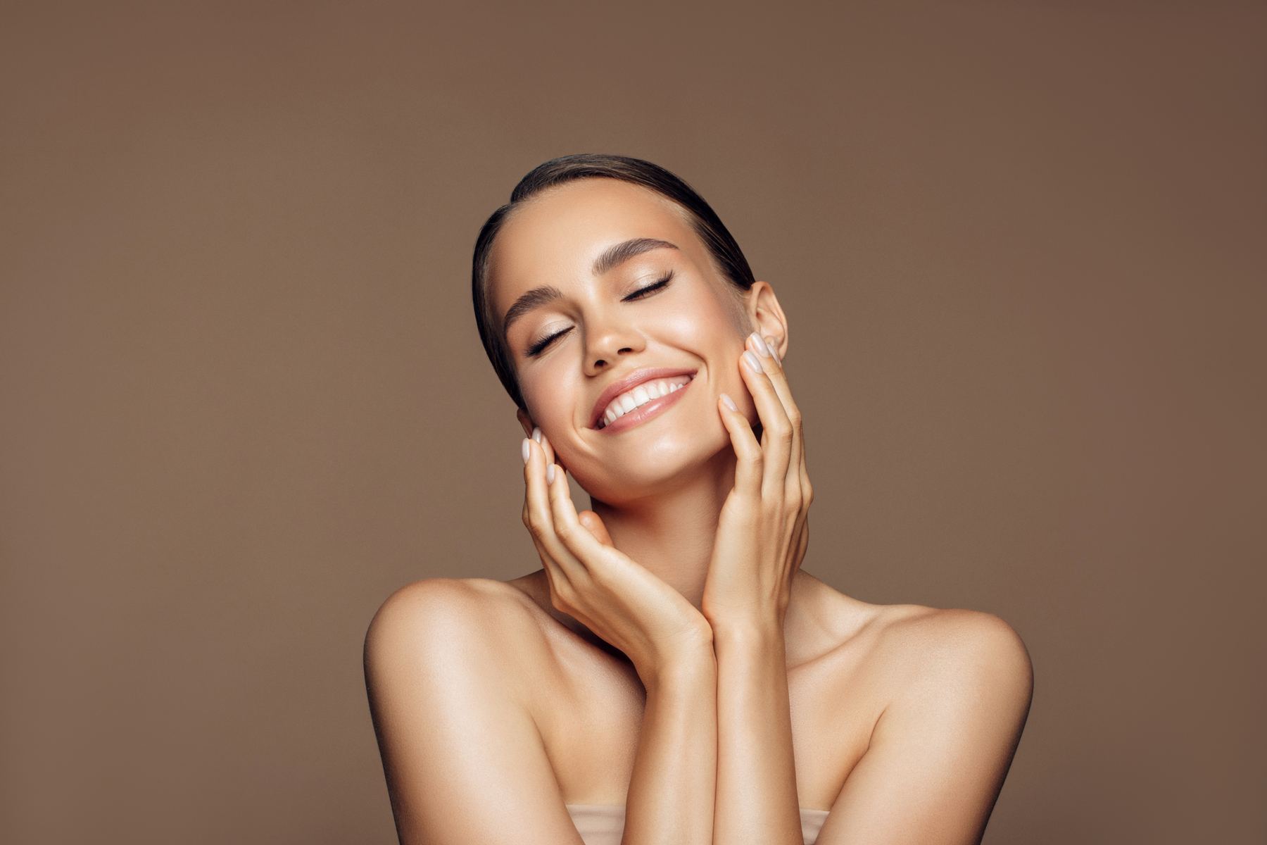 Smilende kvinne med naturlig, glatt hud